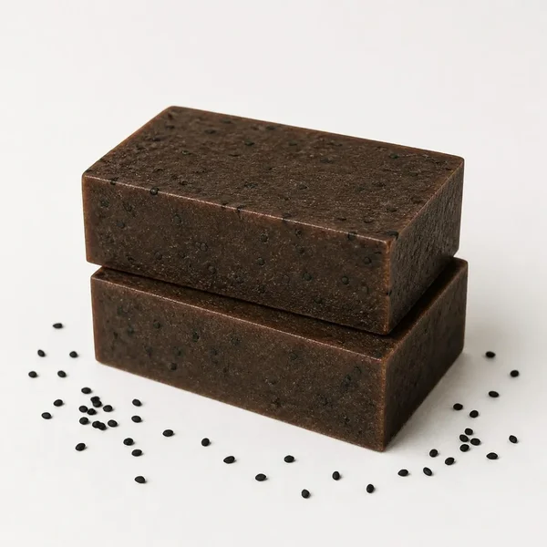Deux pains de savon brun foncé parsemés de graines de nigelle