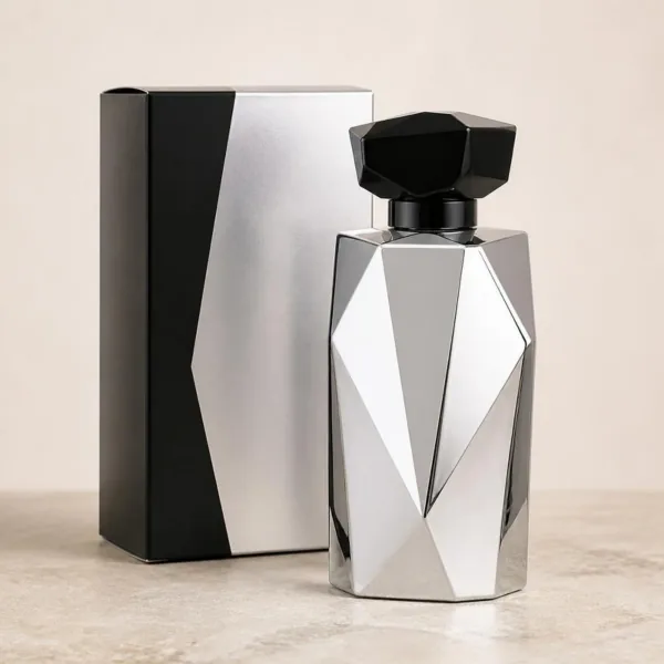 Flacon de parfum argenté à facettes et à bouchon noir anguleux, devant son étui argent et noir