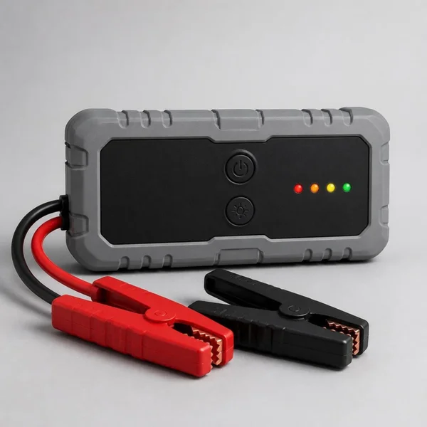 Booster de batterie noir et gris relié à une pince rouge et à une pince noire